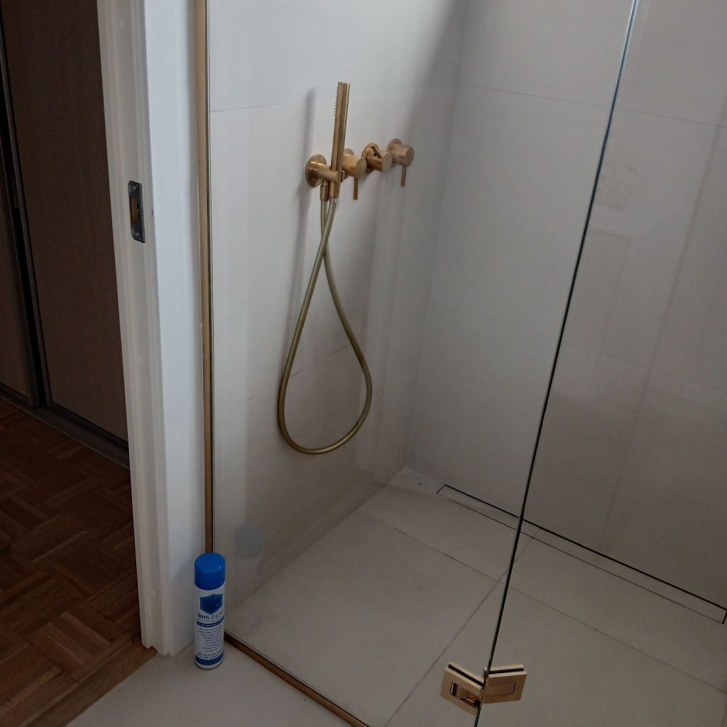 Brusevæg i glas med stabiliseringsstang i ægte messing – moderne glasafskærmning til badeværelse fra BHS Glas